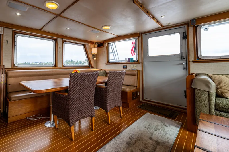 Traveller II Yacht Photos Pics Interior of 2001 Rodriquez Pilothouse with dining area and wooden flooring.