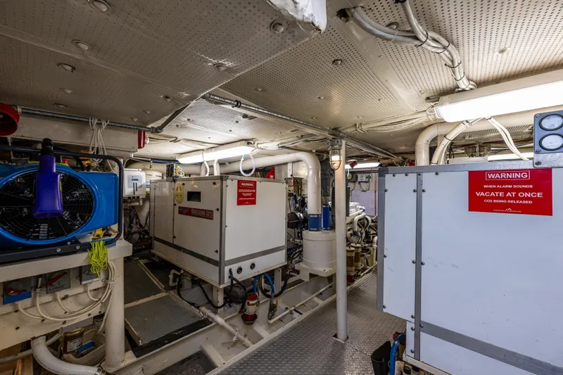 Traveller II Yacht Photos Pics Engine room of 2001 Rodriquez Pilothouse yacht with machinery and warning signs.