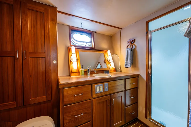 Traveller II Yacht Photos Pics Luxurious 2001 Rodriquez Pilothouse bathroom with wooden cabinetry and modern fixtures.