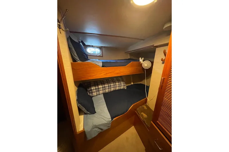 Traveller II Yacht Photos Pics Bunk beds in 2001 Rodriquez Pilothouse cabin with cozy bedding and small fan.