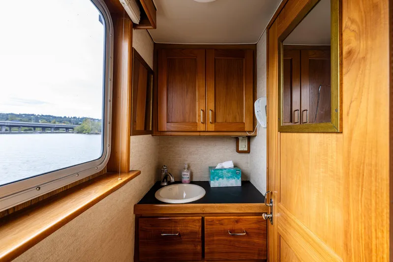 Traveller II Yacht Photos Pics 2001 Rodriquez Pilothouse bathroom with wooden cabinets and scenic window view.