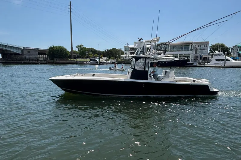  Yacht Photos Pics 2004 SeaVee 34 boat on calm water near marina, clear sky background.