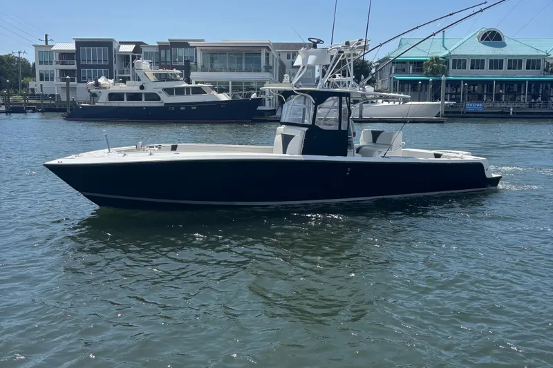  Yacht Photos Pics 2004 SeaVee 34 boat on water, with modern buildings in the background.