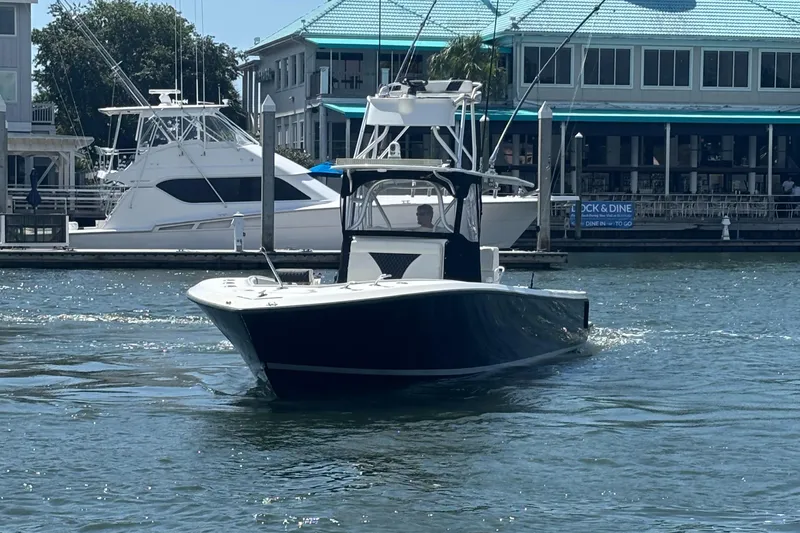  Yacht Photos Pics 2004 SeaVee 34 boat cruising near a marina with docked yachts.