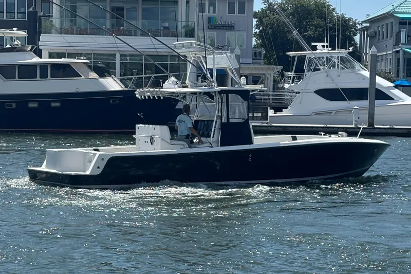  Yacht Photos Pics 2004 SeaVee 34 boat cruising in a marina with other yachts in the background.