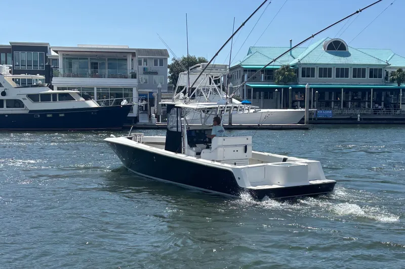  Yacht Photos Pics 2004 SeaVee 34 boat cruising in a marina with waterfront buildings in the background.