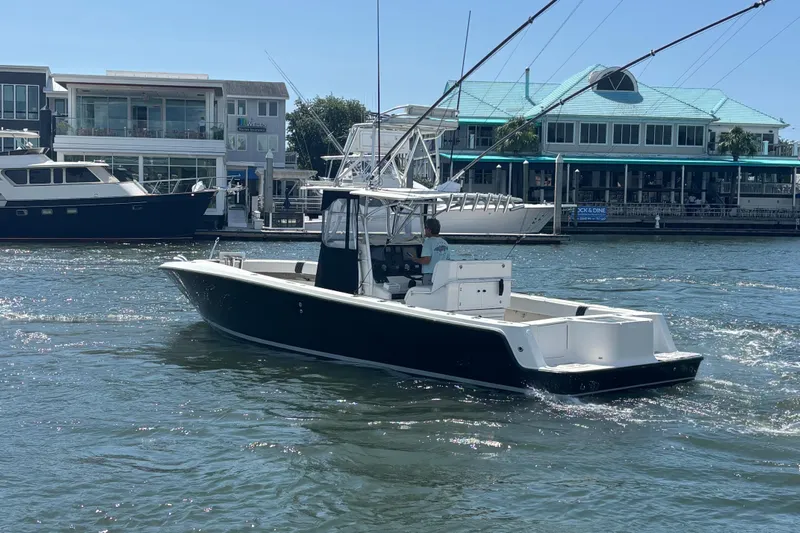 Yacht Photos Pics 2004 SeaVee 34 boat cruising in a marina with waterfront buildings in the background.