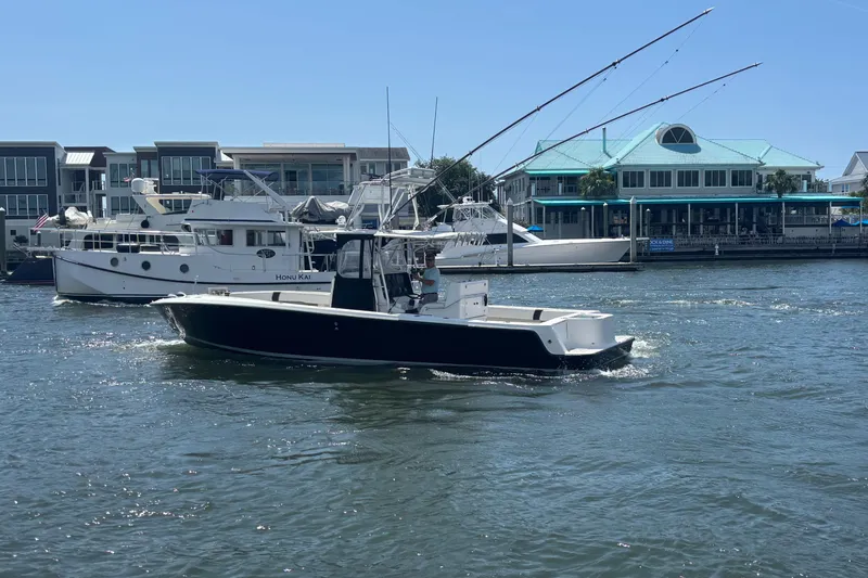  Yacht Photos Pics 2004 SeaVee 34 boat cruising on a sunny day near waterfront buildings.