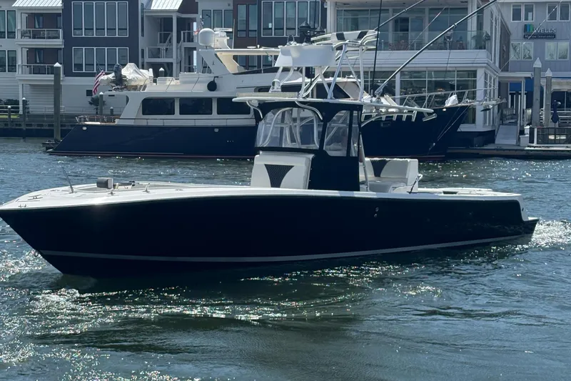  Yacht Photos Pics 2004 SeaVee 34 boat on water, with modern buildings and yachts in the background.