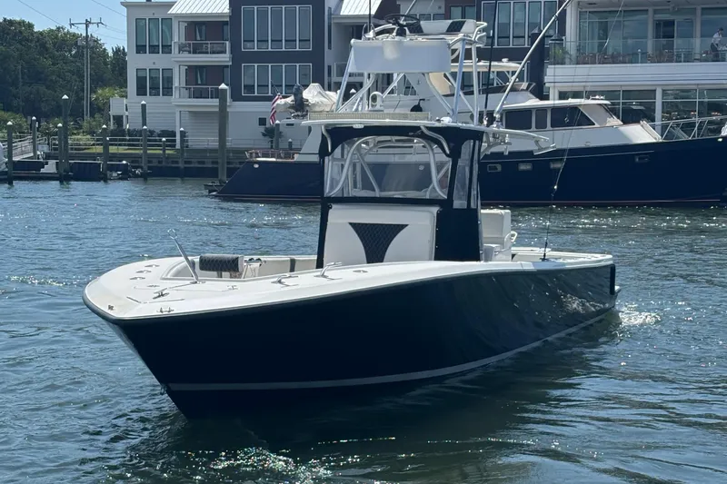  Yacht Photos Pics 2004 SeaVee 34 boat on water near marina with modern buildings in background.