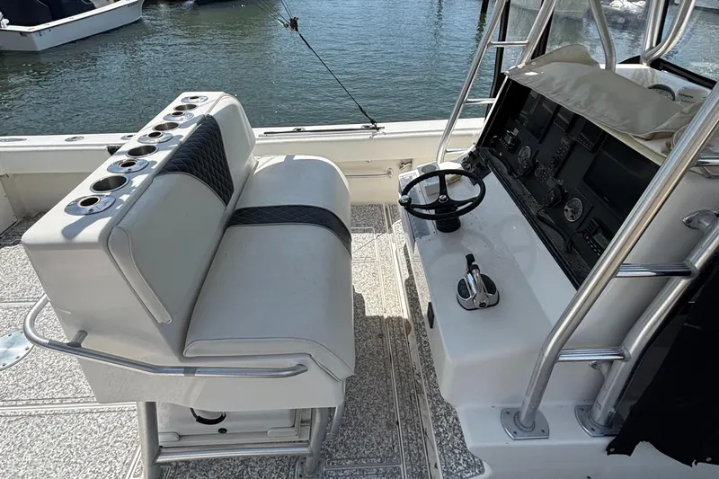 Yacht Photos Pics 2004 SeaVee 34 boat cockpit with seating, steering wheel, and control panel by the water.