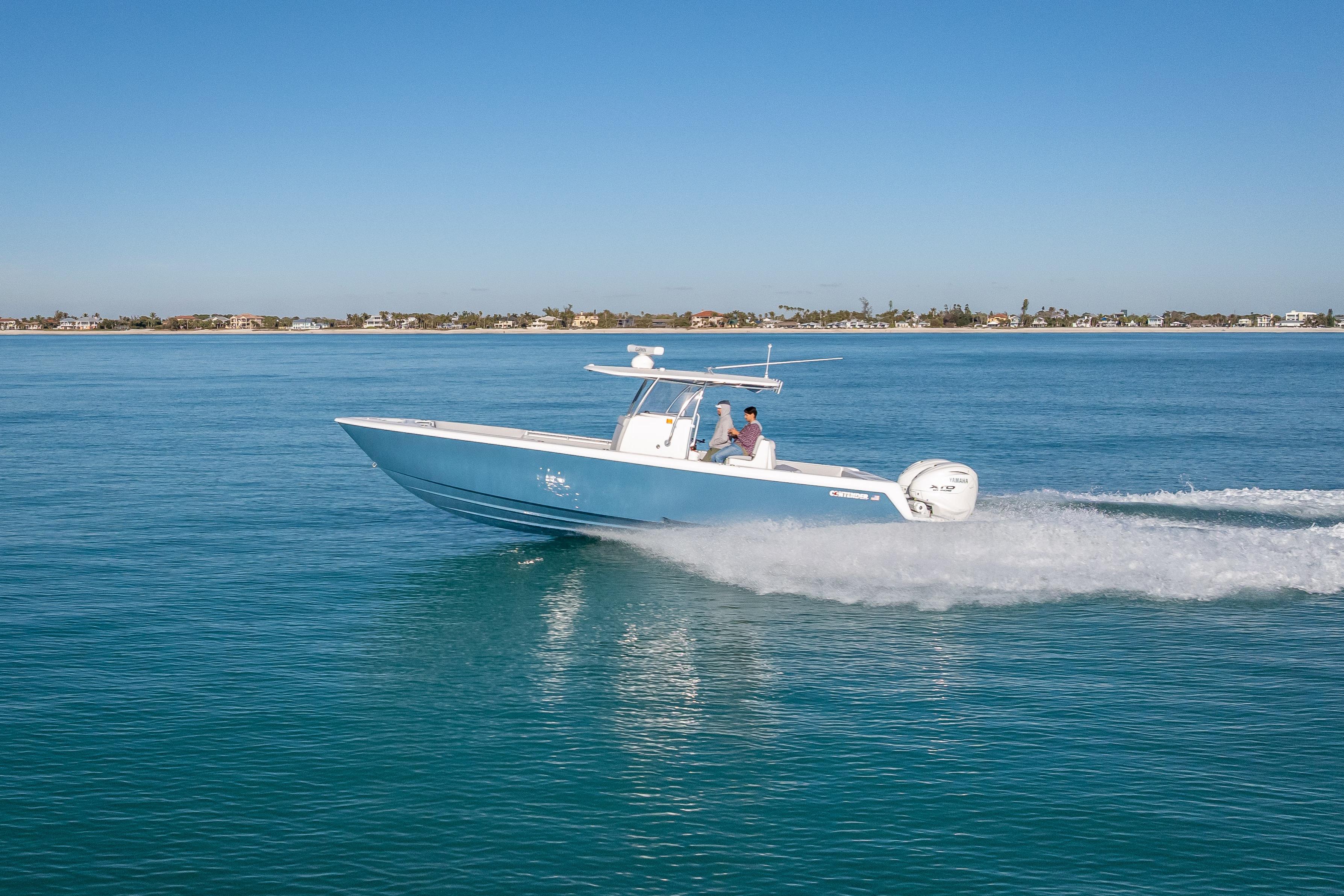 2026 Contender 35 ST boat cruising on clear blue water under a sunny sky.