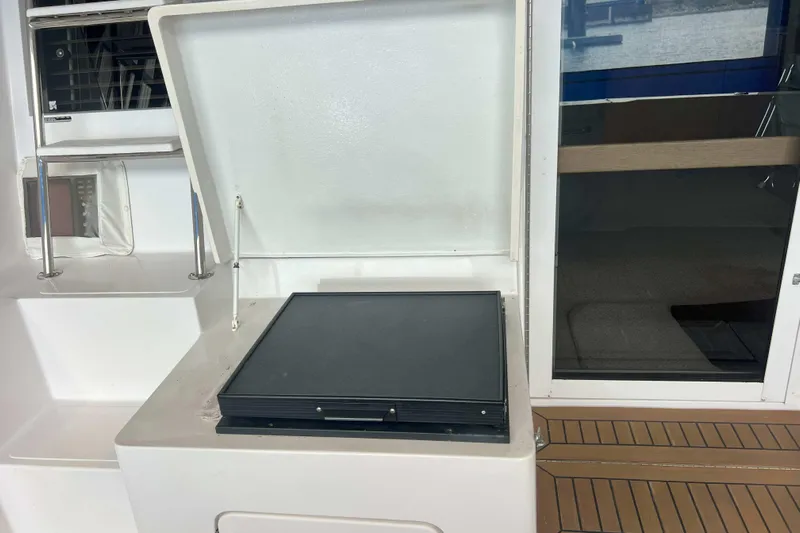 Dream Catcher Yacht Photos Pics 1998 West Bay 58 yacht interior with open storage compartment and wooden flooring.