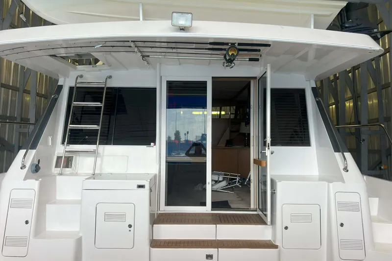 Dream Catcher Yacht Photos Pics 1998 West Bay 58 yacht stern view with ladder and sliding doors in marina.