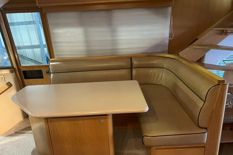 Dream Catcher Yacht Photos Pics Cozy dining area in 1998 West Bay 58 yacht with beige leather seating and wooden table.