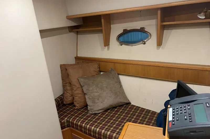 Dream Catcher Yacht Photos Pics Cozy cabin interior of 1998 West Bay 58 yacht with plaid bedding and porthole.