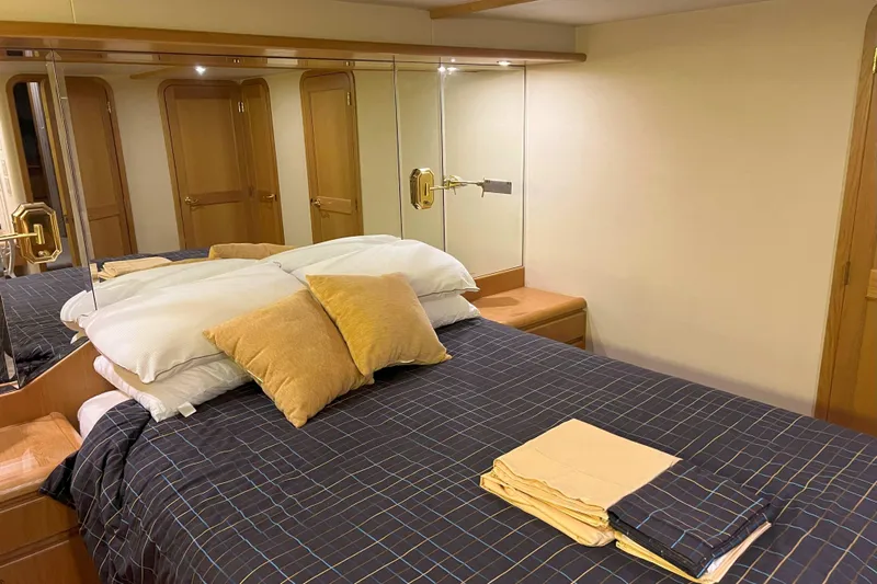 Dream Catcher Yacht Photos Pics Luxurious bedroom interior of 1998 West Bay 58 yacht with plush bedding and mirrored walls.