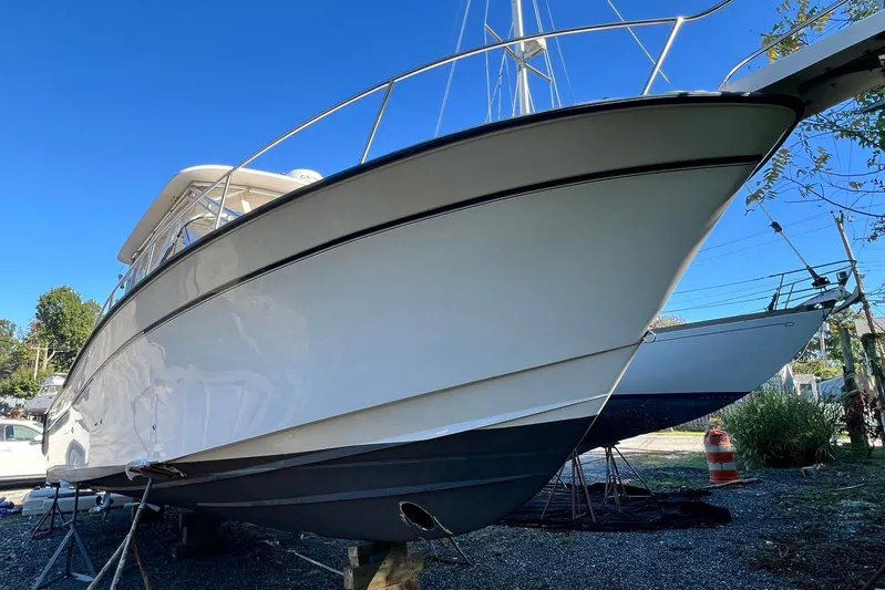 Zig Zag Yacht Photos Pics 2004 Grady-White Express 330 boat on dry dock, clear blue sky background.