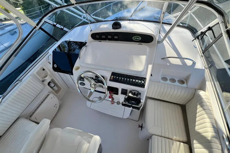 Zig Zag Yacht Photos Pics 2004 Grady-White Express 330 helm with steering wheel, controls, and seating.