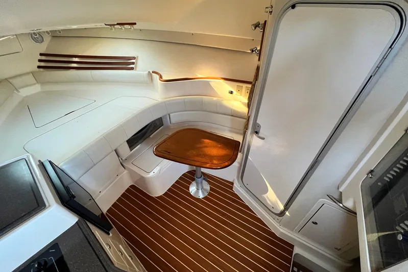 Zig Zag Yacht Photos Pics 2004 Grady-White Express 330 cabin interior with seating, table, and wood flooring.