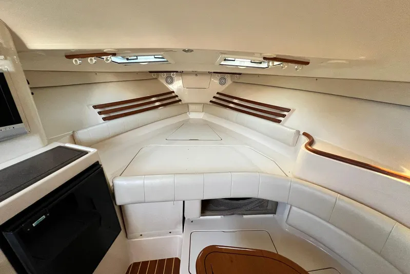 Zig Zag Yacht Photos Pics 2004 Grady-White Express 330 cabin interior with white seating and wood accents.
