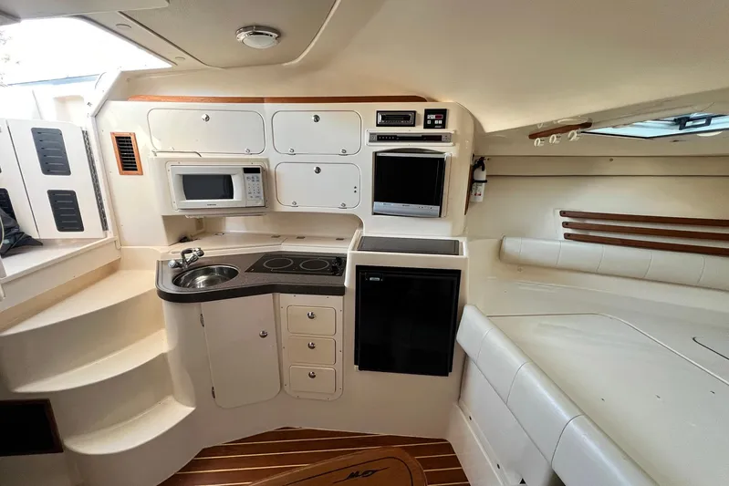 Zig Zag Yacht Photos Pics 2004 Grady-White Express 330 cabin interior with kitchenette and seating area.