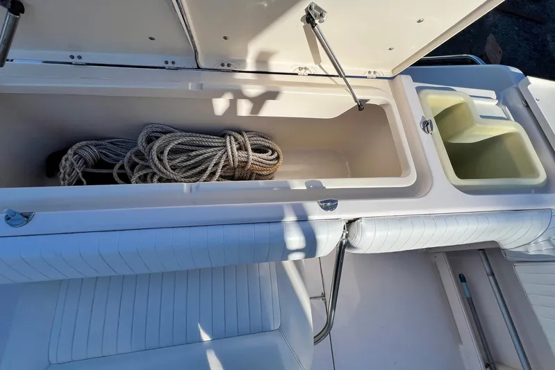 Zig Zag Yacht Photos Pics 2004 Grady-White Express 330 boat storage compartment with coiled rope and utility bins.