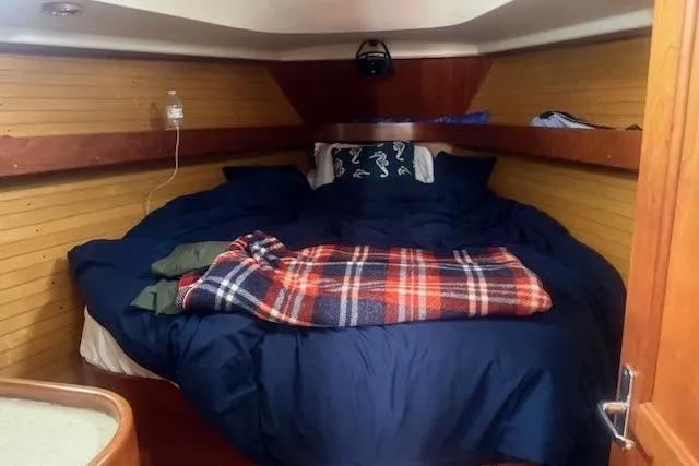 Midnight Yacht Photos Pics Cozy cabin interior of 2005 Sabre 386 sailboat with bed and plaid blanket.