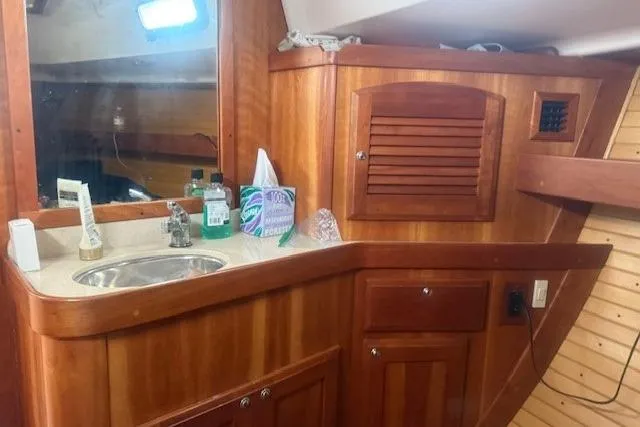 Midnight Yacht Photos Pics Wooden interior of a 2005 Sabre 386 yacht with sink and storage cabinets.