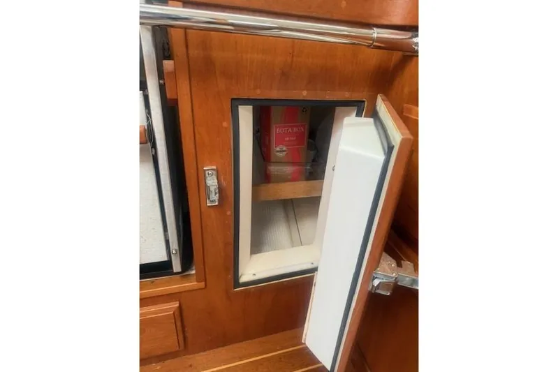 Midnight Yacht Photos Pics 2005 Sabre 386 yacht interior with open wooden cabinet and visible storage.