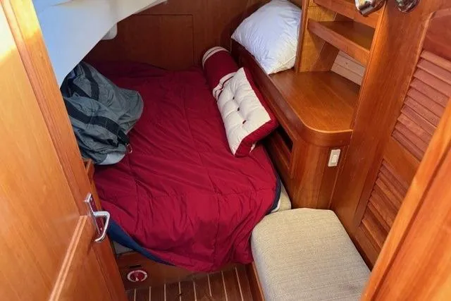 Midnight Yacht Photos Pics Cozy cabin interior of 2005 Sabre 386 sailboat with red bedding and wooden furnishings.