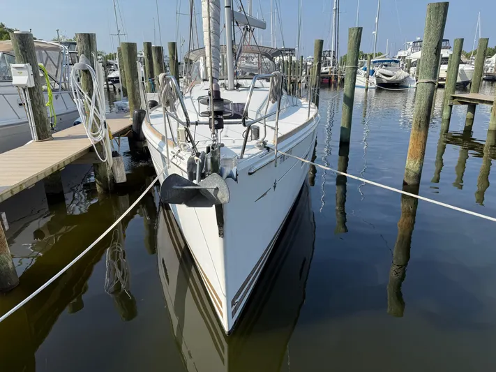 Ma Bro Yacht Photos Pics 2014 Jeanneau Sun Odyssey 409 sailboat docked at marina, surrounded by wooden posts.