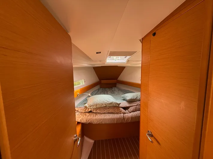 Ma Bro Yacht Photos Pics Cozy cabin interior of 2014 Jeanneau Sun Odyssey 409 sailboat with bed and wooden finish.
