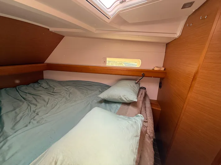 Ma Bro Yacht Photos Pics Cozy cabin interior of 2014 Jeanneau Sun Odyssey 409 sailboat with bed and wooden paneling.