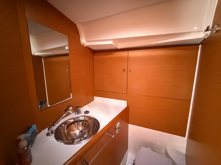 Ma Bro Yacht Photos Pics 2014 Jeanneau Sun Odyssey 409 bathroom with wooden cabinetry and stainless steel sink.
