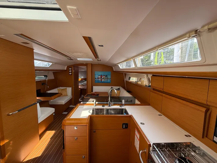 Ma Bro Yacht Photos Pics Interior of 2014 Jeanneau Sun Odyssey 409 sailboat, featuring modern kitchen and seating area.
