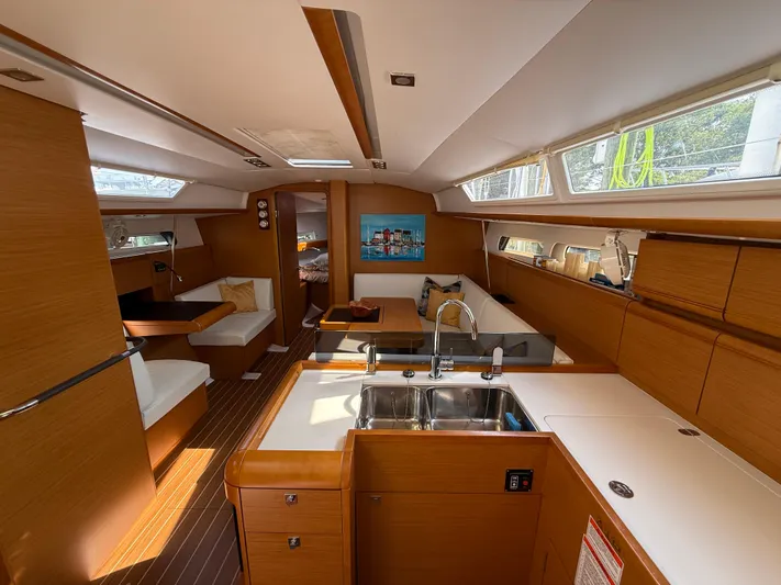 Ma Bro Yacht Photos Pics Interior of 2014 Jeanneau Sun Odyssey 409 sailboat with modern kitchen and seating area.