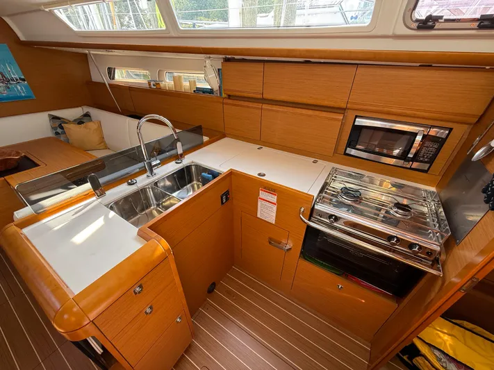Ma Bro Yacht Photos Pics 2014 Jeanneau Sun Odyssey 409 yacht kitchen with modern appliances and wooden cabinetry.