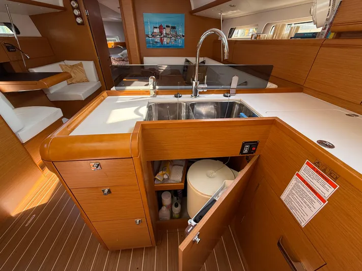 Ma Bro Yacht Photos Pics Interior of 2014 Jeanneau Sun Odyssey 409 yacht, featuring a modern kitchen with wood finish.