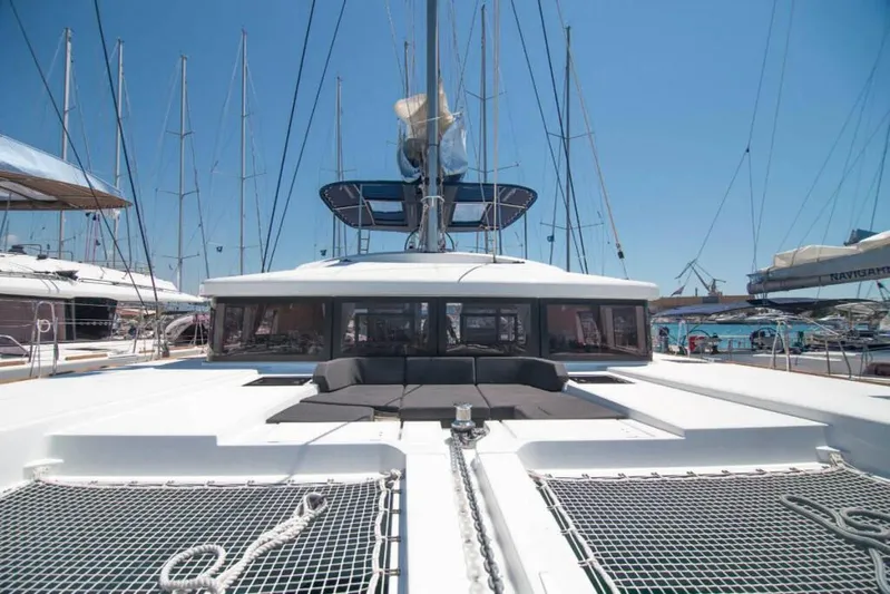 Costabella Yacht Photos Pics 2018 Lagoon 52 F catamaran docked at marina, showcasing spacious deck and netting.