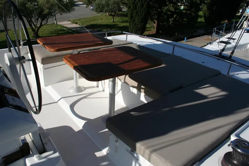 Costabella Yacht Photos Pics Flybridge seating area on 2018 Lagoon 52 F catamaran with wooden tables and cushioned benches.