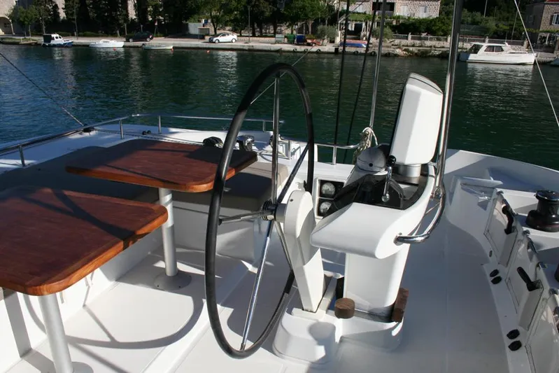 Costabella Yacht Photos Pics Helm and seating area on 2018 Lagoon 52 F catamaran, docked by the water.
