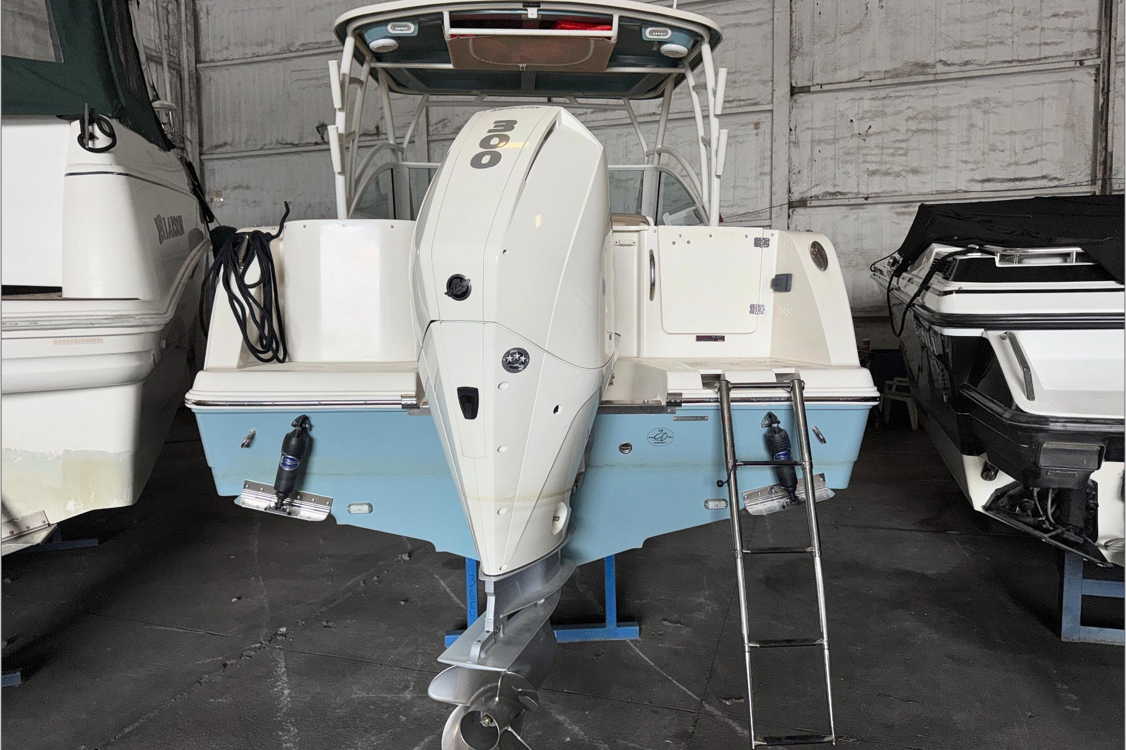 2021 Sailfish 245 DC boat in storage, featuring a powerful outboard motor.