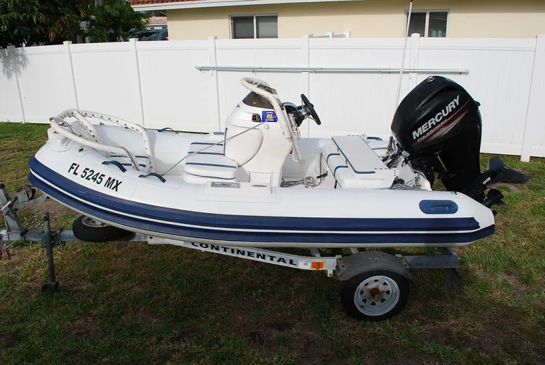 No Name Yacht Photos Pics Small inflatable boat with Mercury outboard motor on trailer, Fairline Squadron 2000 model.