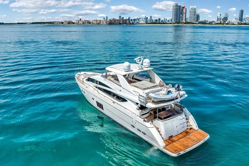 Princess Y85 Yacht Photos Pics Luxurious 2012 Princess 85 yacht cruising in clear blue waters near a city skyline.