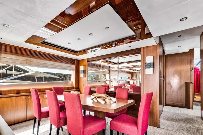 Princess Y85 Yacht Photos Pics Luxurious dining area on a 2012 Princess 85 yacht with red chairs and wooden accents.