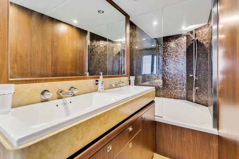 Princess Y85 Yacht Photos Pics Luxurious yacht bathroom with dual sinks, modern fixtures, and elegant wood paneling.