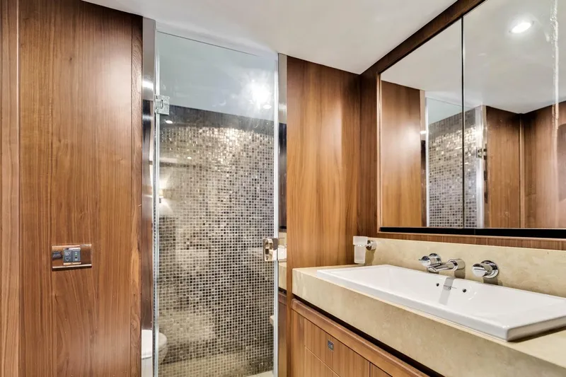 Princess Y85 Yacht Photos Pics Luxurious yacht bathroom with wood paneling, modern sink, and glass shower. Princess 85, 2012 model.