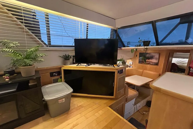 Contentment Yacht Photos Pics Interior of 1995 Carver 440 Aft Cabin Motor Yacht with TV, plants, and seating area.