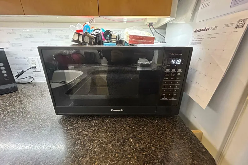 Contentment Yacht Photos Pics Panasonic microwave on kitchen counter with November 2025 calendar in background.